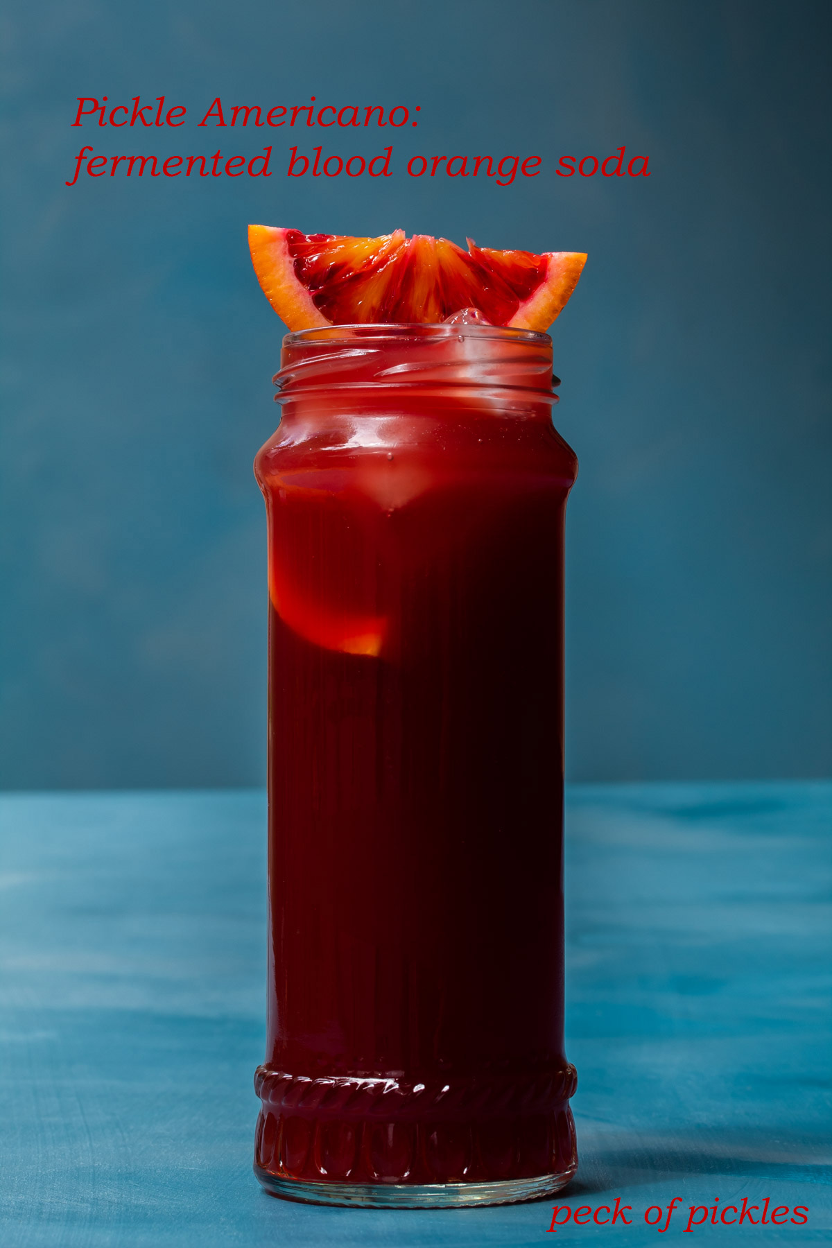 pickle blood orange Americano cocktail isolated on blue background