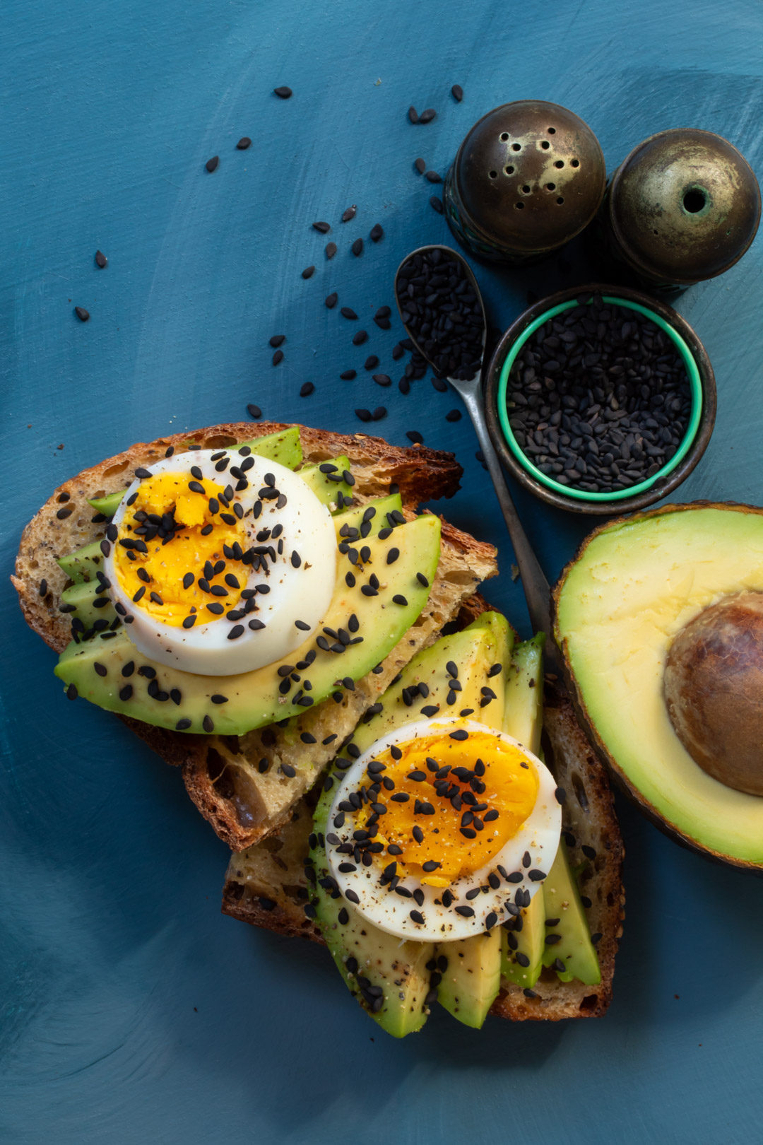 avocado toasts with hard boiled eggs blue background