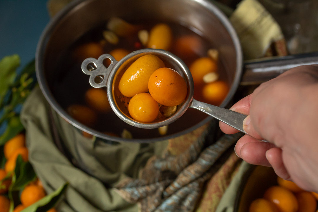 pickling cumquats straining into bowl