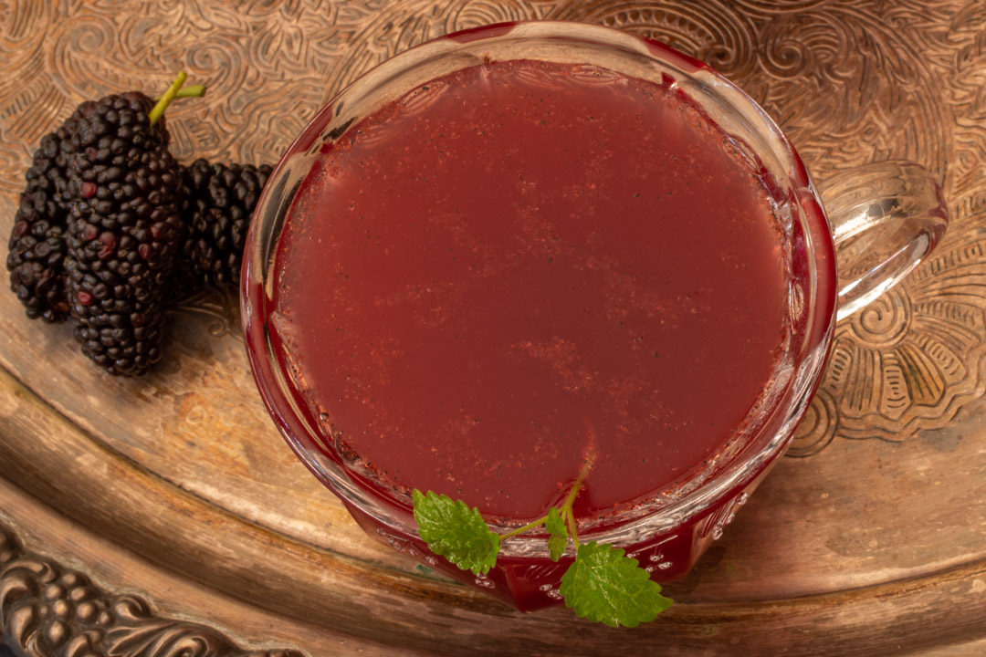 spiced mulberry shrub on tray with three berries