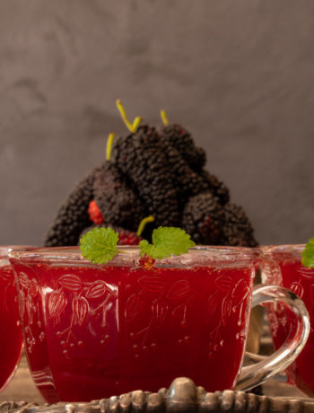 spiced mulberry shrub with mulberries in background