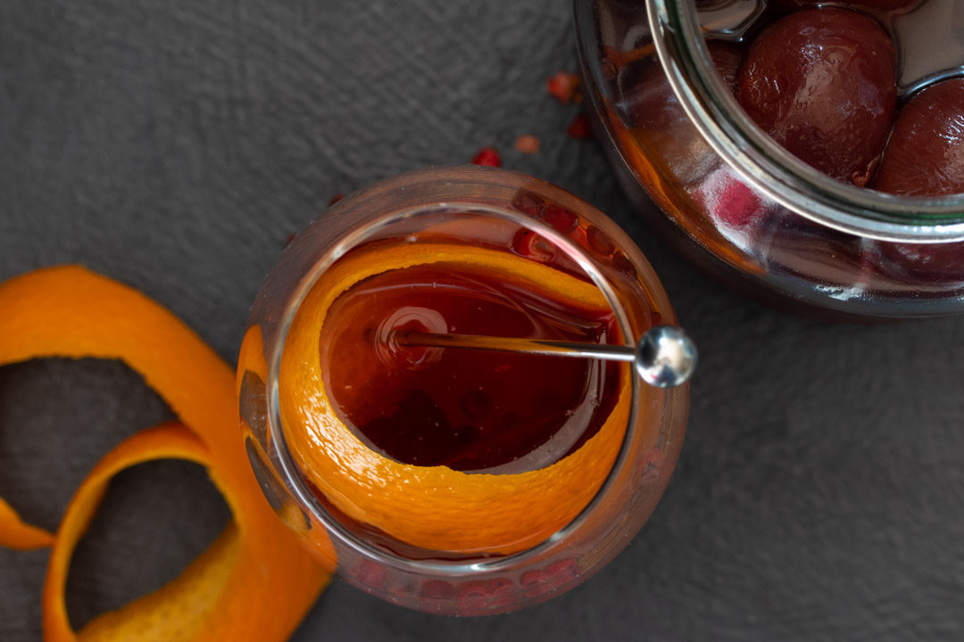 new old fashioned with orange peel and pickled cherry jar