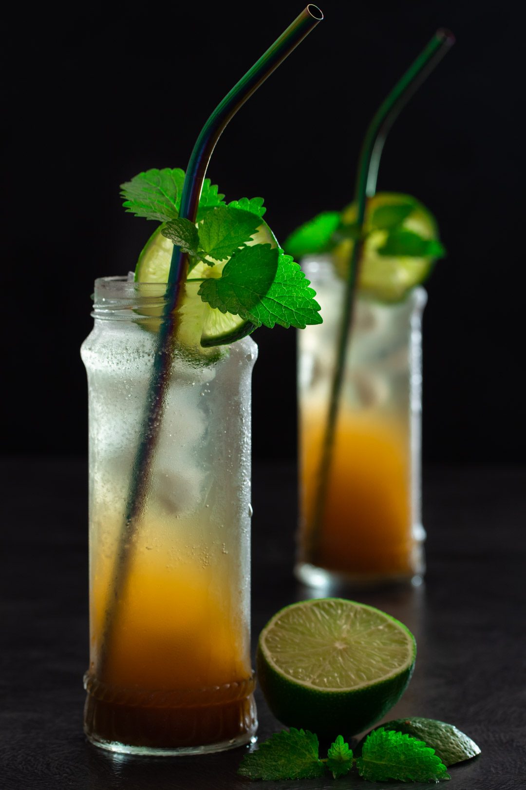 Ginger lime shrub syrup drinking vinegar: with lime and lemon balm in foreground