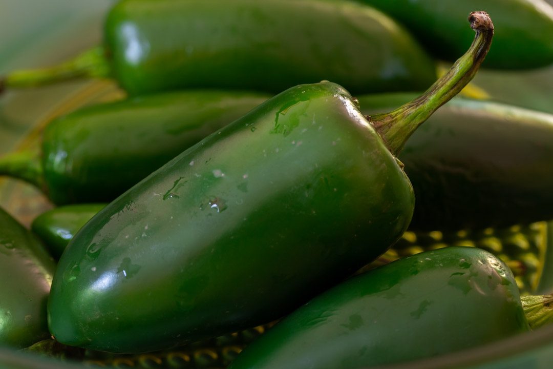 Jalapeno pickles with pepper berries & ginger: still life green glass bowl