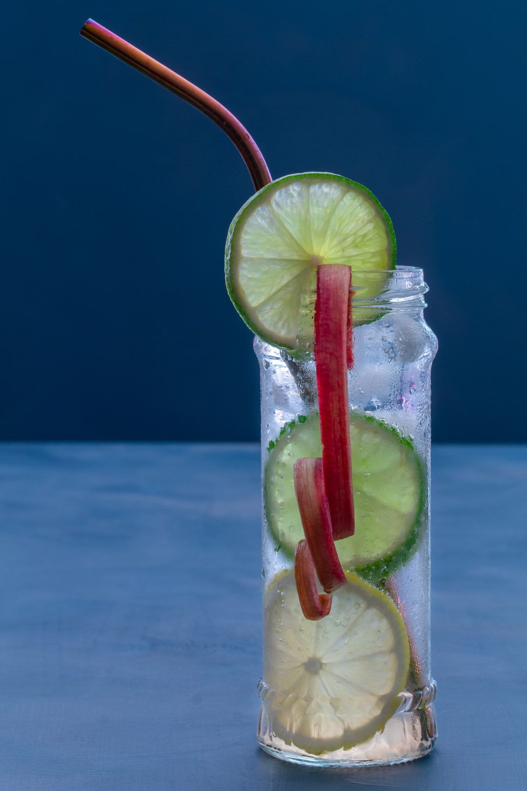 lemon, lime and rhubarb bitters with straw left and rhubarb ribbon centre