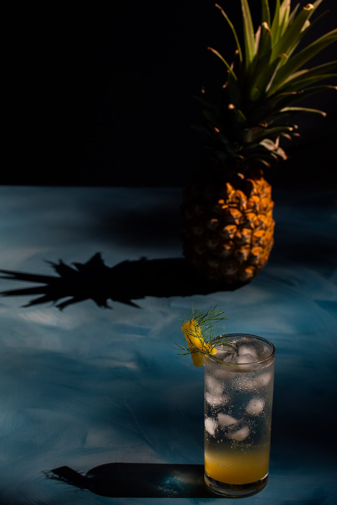 pineapple fennel shrub syrup from 45 degrees with pineapple and shadow in background
