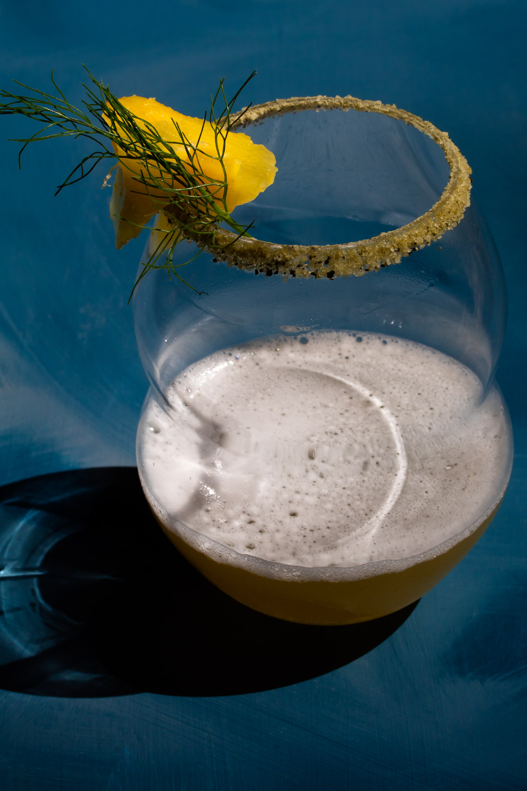 pineapple fennel shrub margarita cocktail isolated on blue background