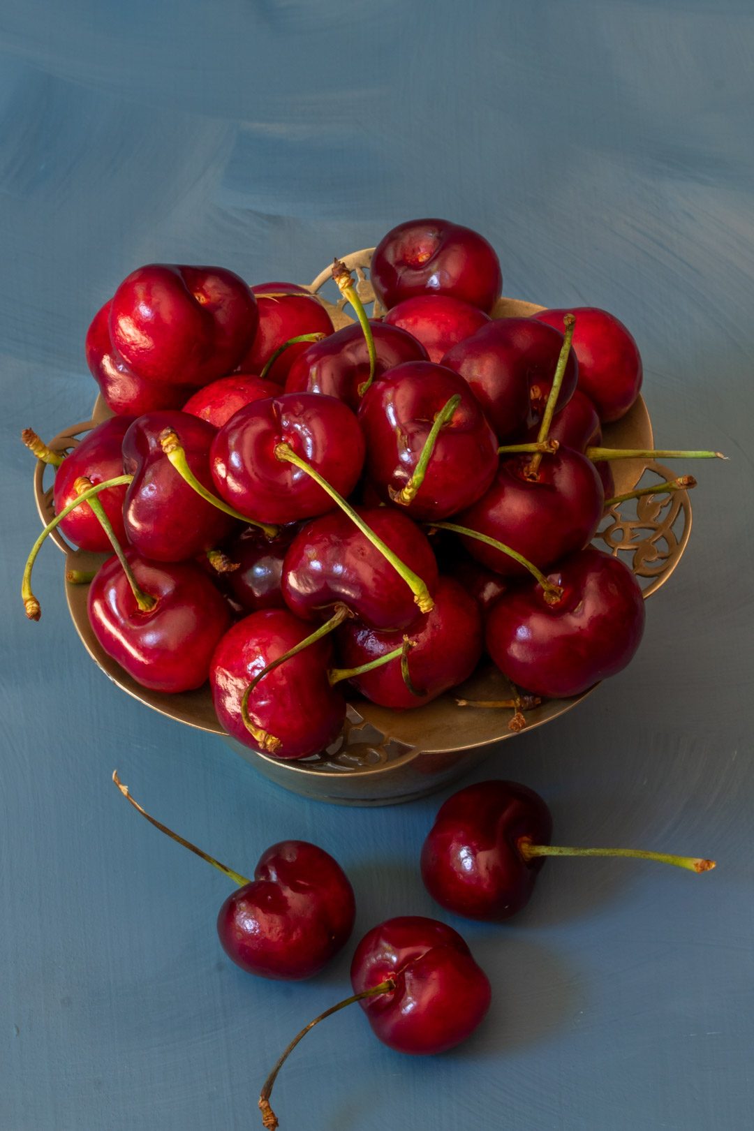 Making spiced pickled cherries with cherries in vintage sugar bowl from above