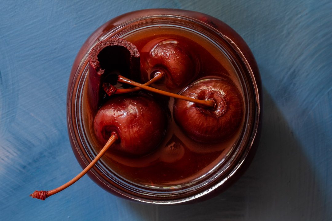 Spiced pickled cherries close up from above