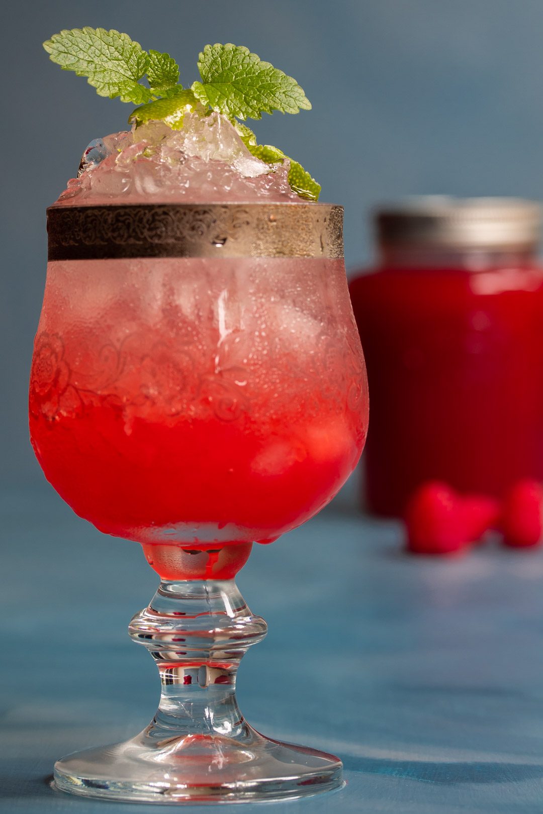 Raspberry shrub syrup drinking vinegar with preserving jar in background