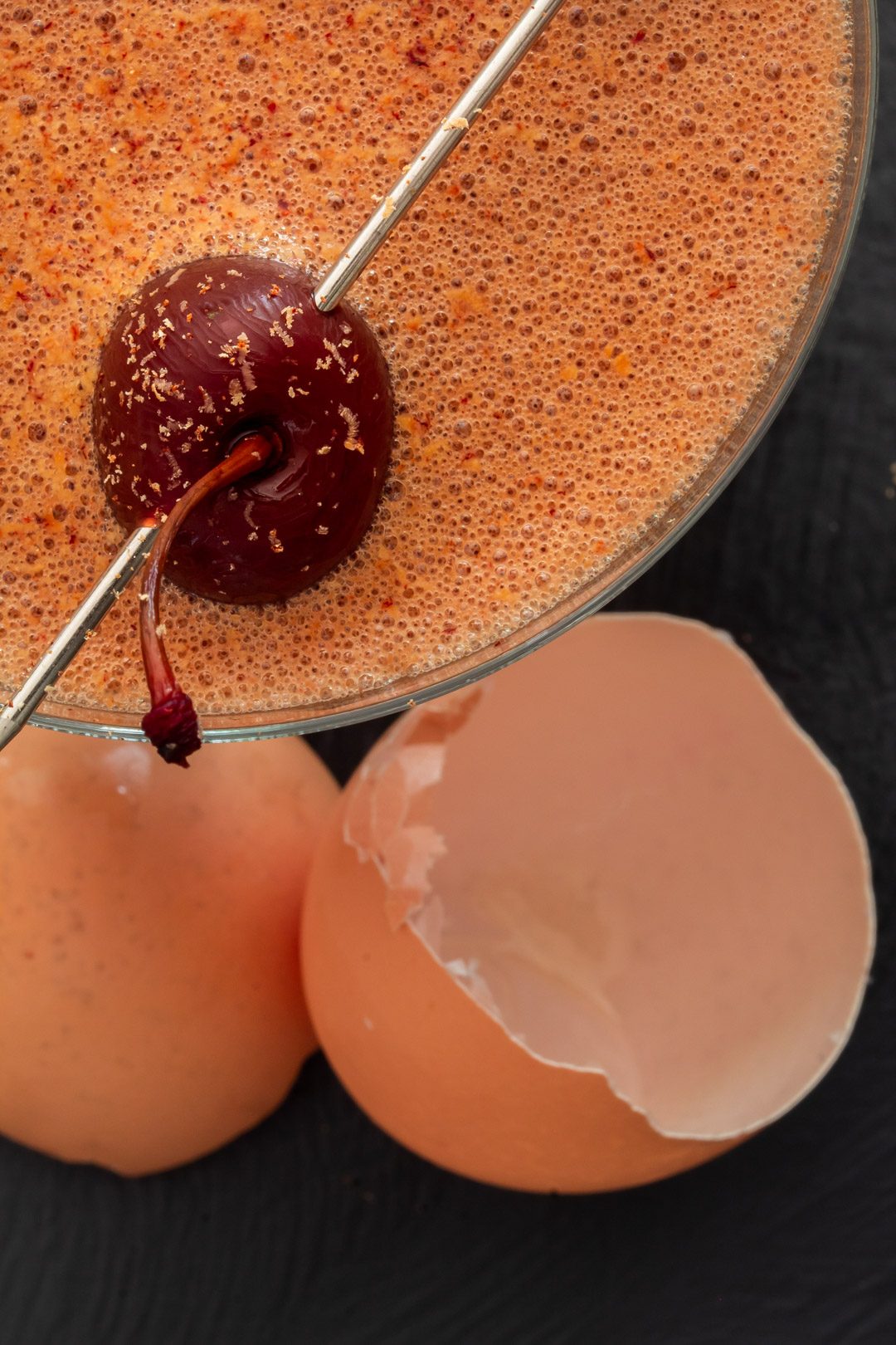 pickled cherry chocolate sherry flip cocktail from above with egg shell