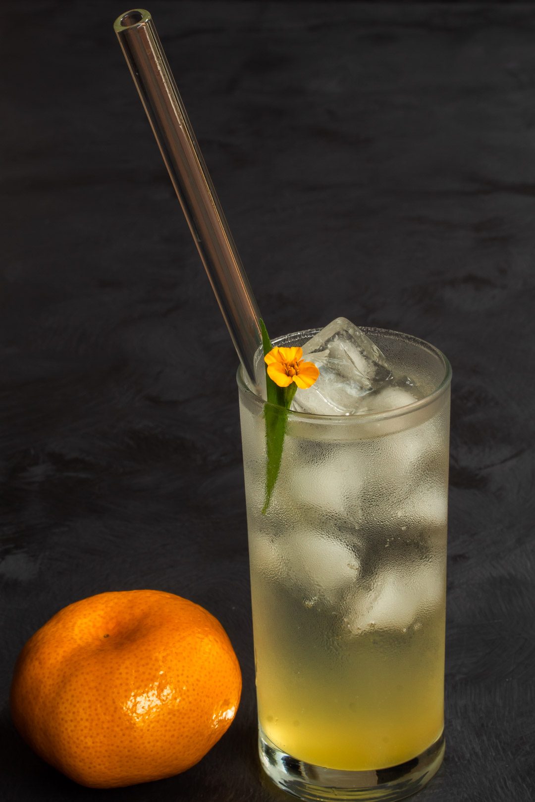 Mandarin tarragon shrub syrup drinking vinegar with mandarin in foreground from 45 degrees