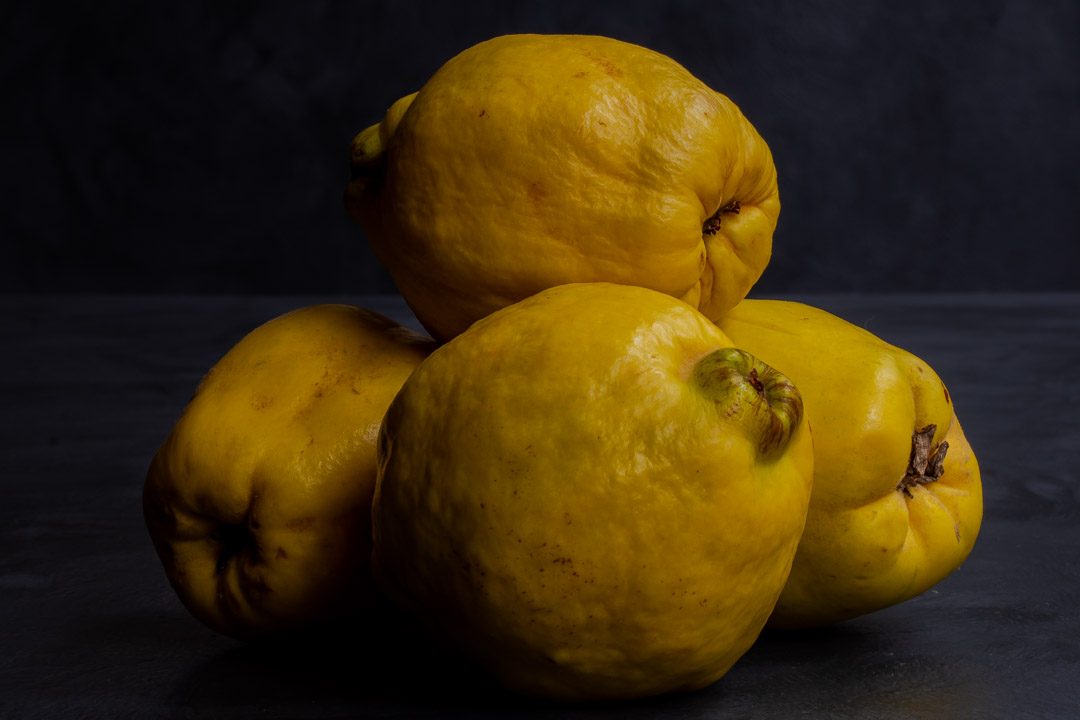 Making Vintage Quince Cordial with quinces in pile