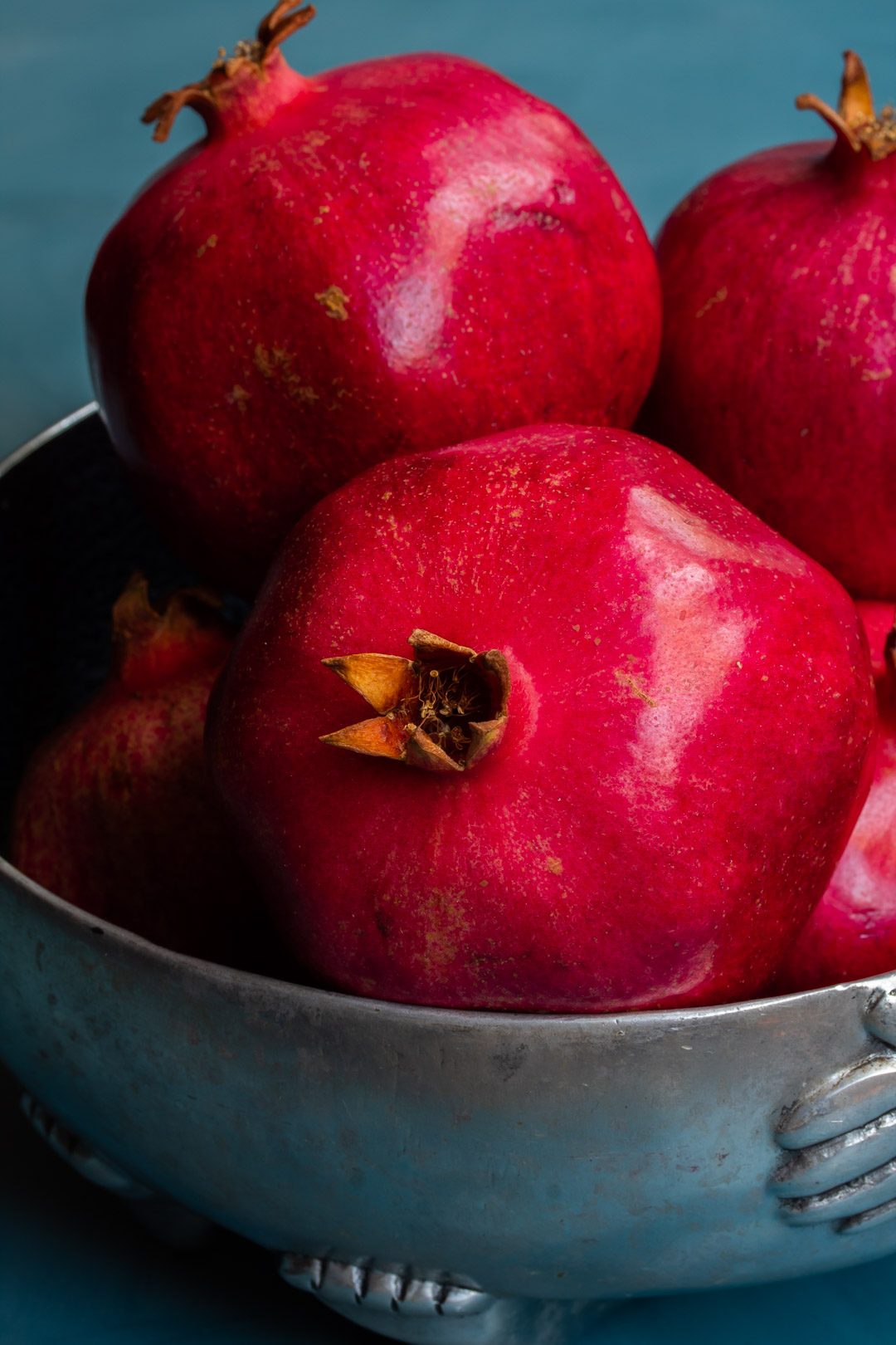 pomegranates in metal bowl from 45 degrees used to make grenadine