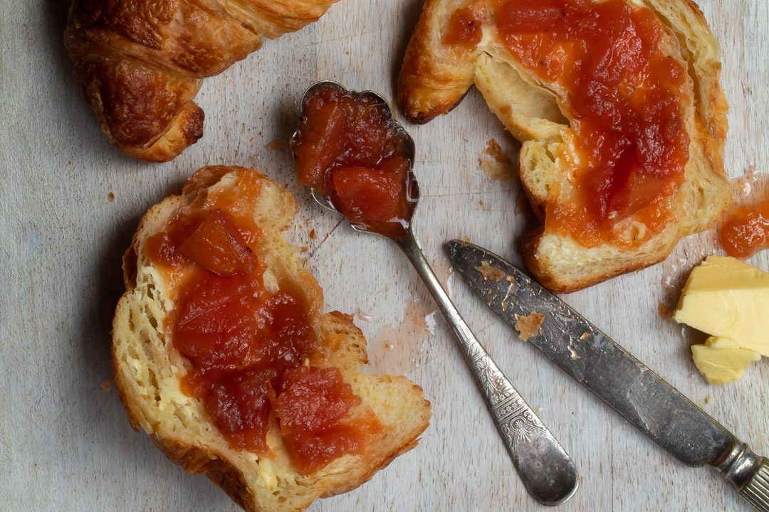 rustic quince apple jam on vintage spoon with split croissant