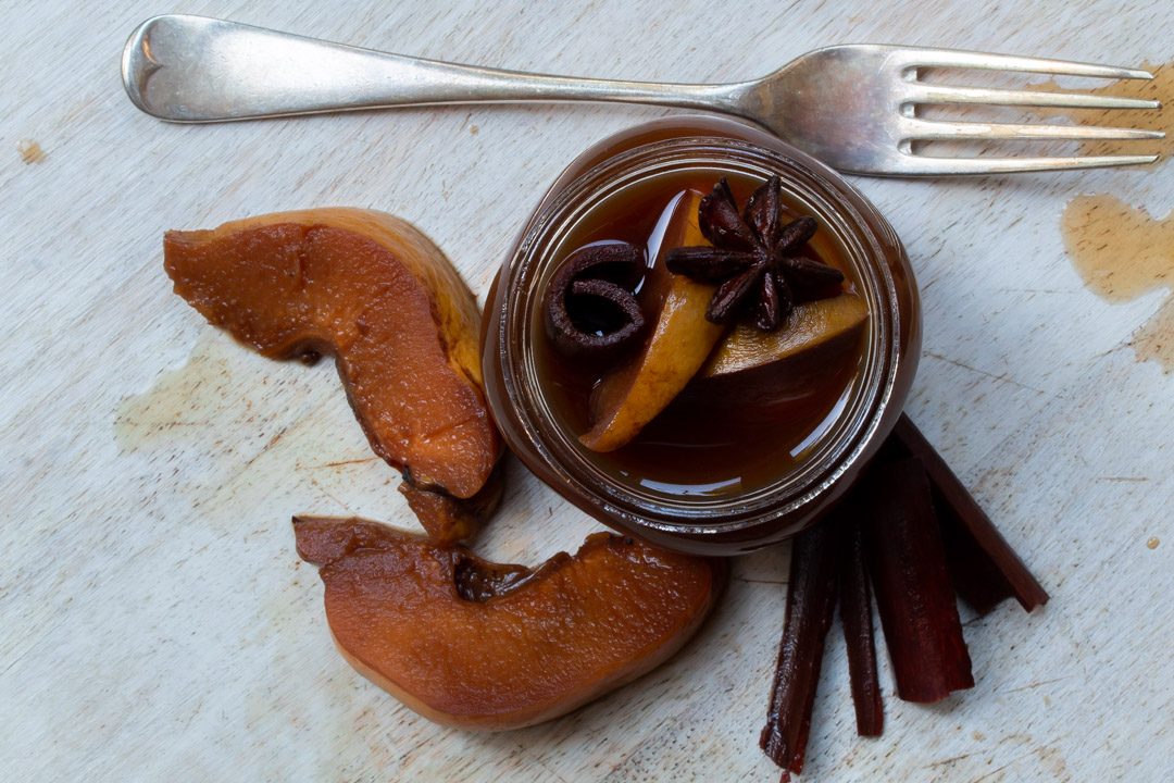 Spiced pickled quinces with fork