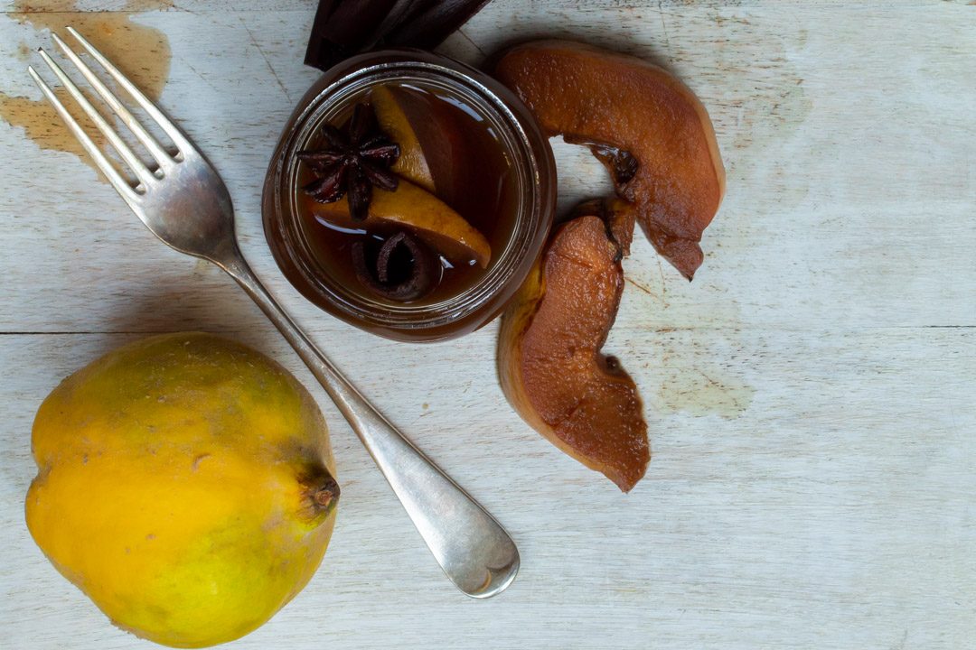 Spiced pickled quinces with fork and quince