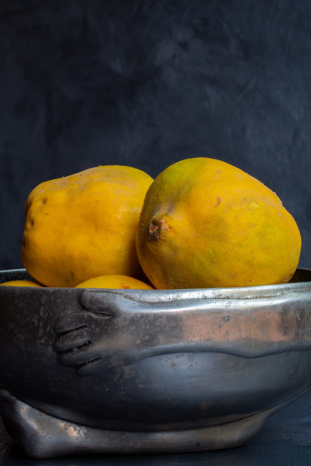 Making spiced pickled quinces with quinces in metal bowl from eye level