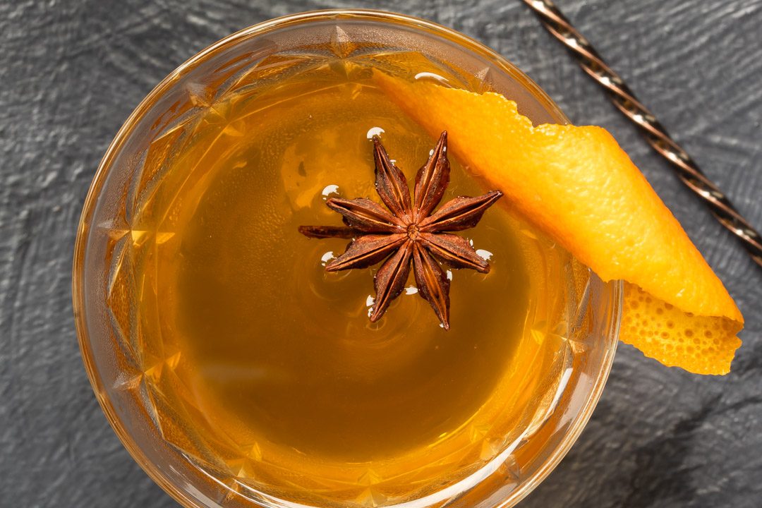 Quince pickle brandy sour cocktail viewed from above with bar spoon detail