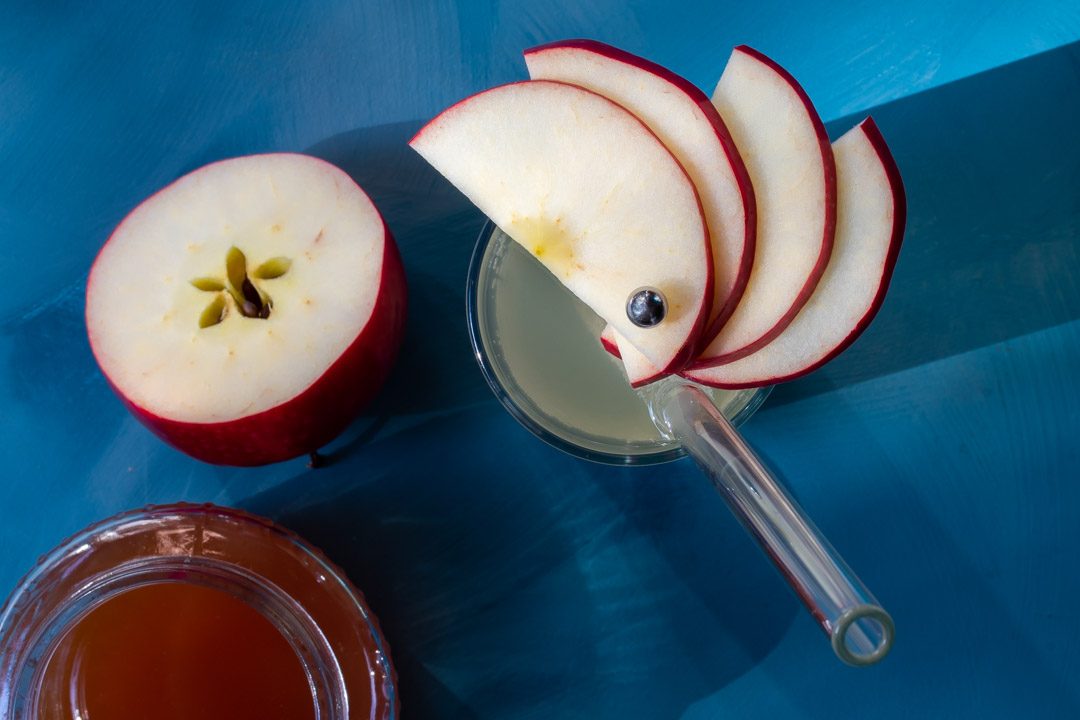 apple shrub gin fizz cocktail from above with apple fan garnish