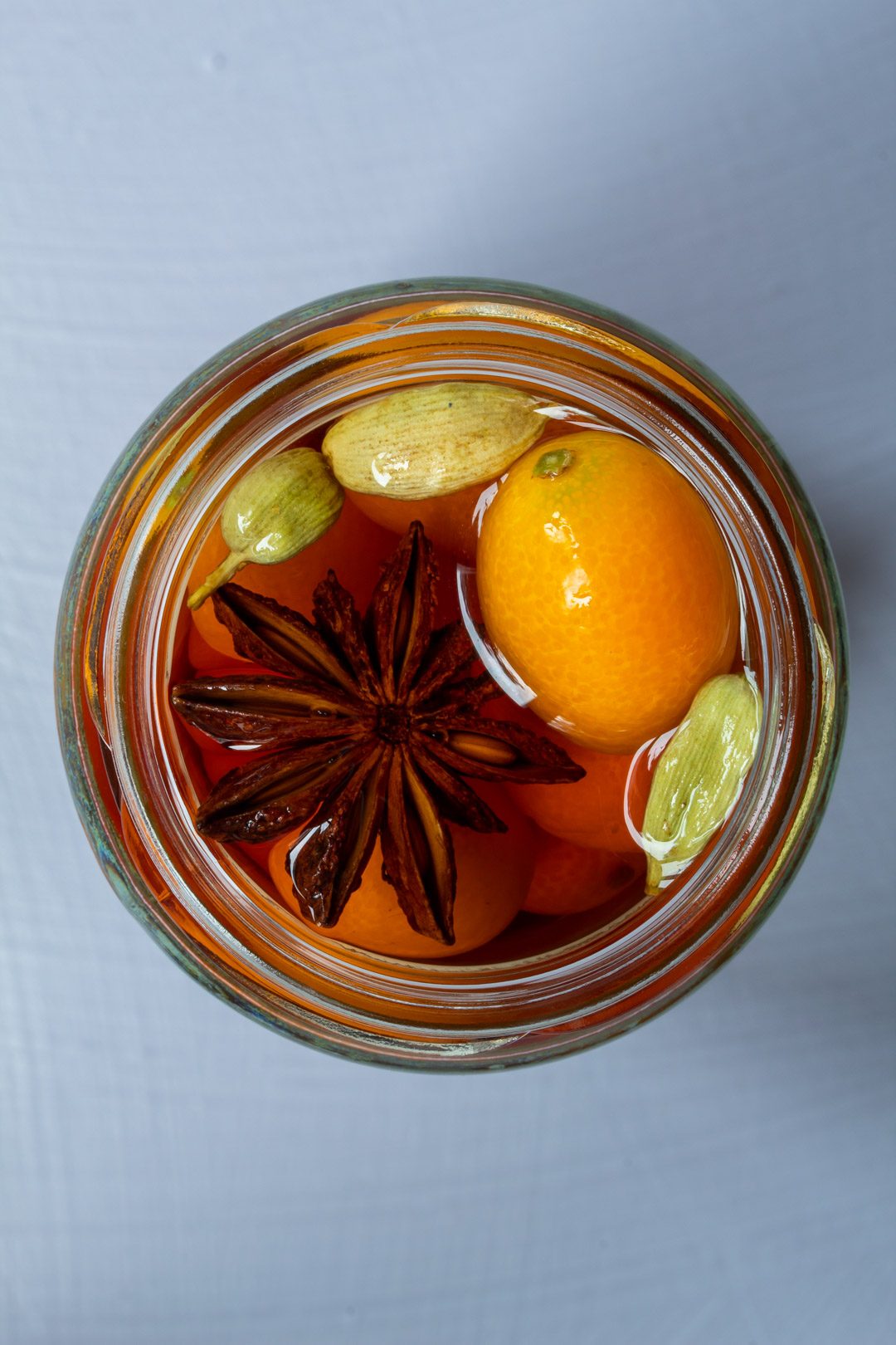 cumquat brandy from above isolated on light purple background