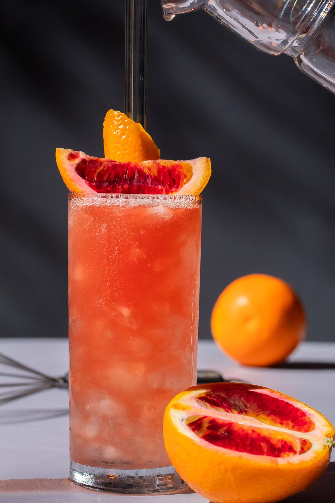 improved blood orangeade with drip falling from jug above full glass