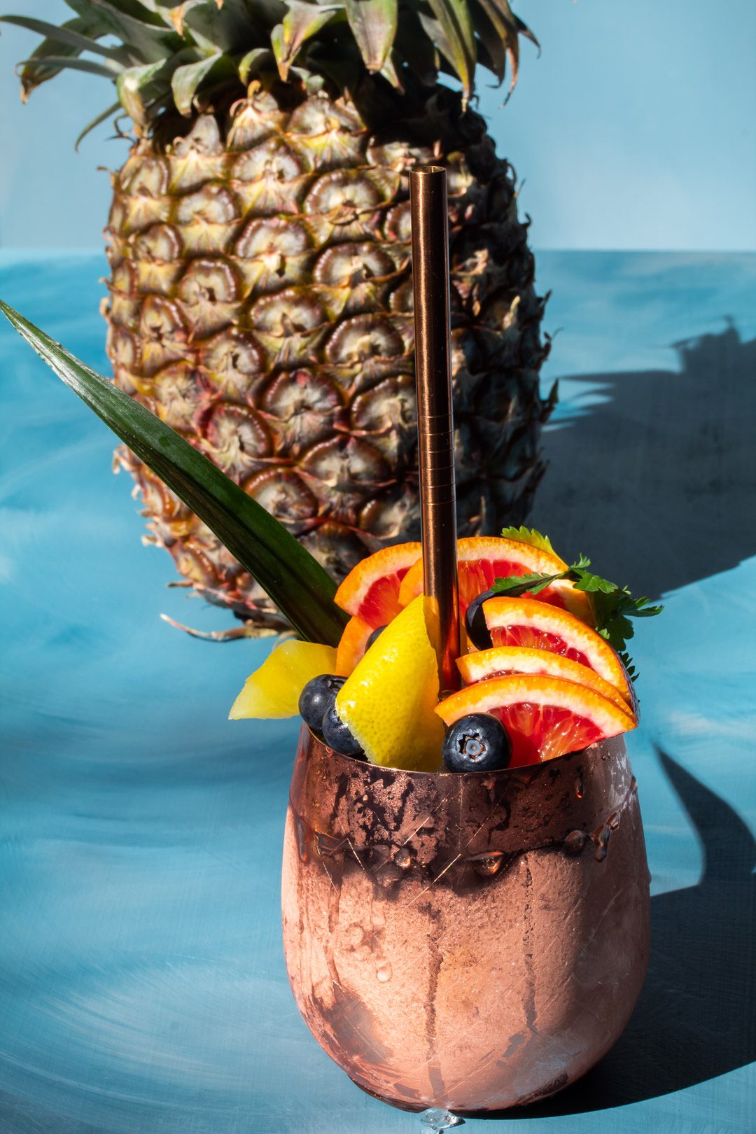 pineapple shrub gin fix cocktail from 45 degree angle with pineapple in background