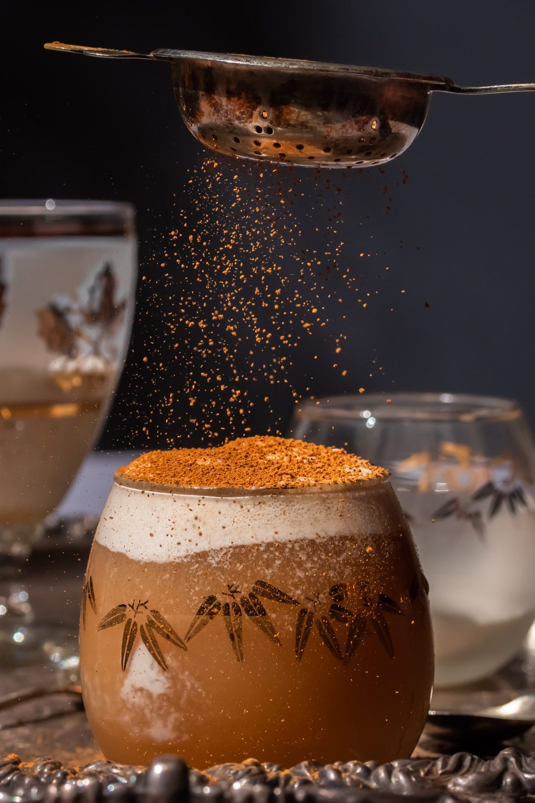 sprinkling cinnamon on lemon myrtle ginger beer spiders with vintage tea strainer