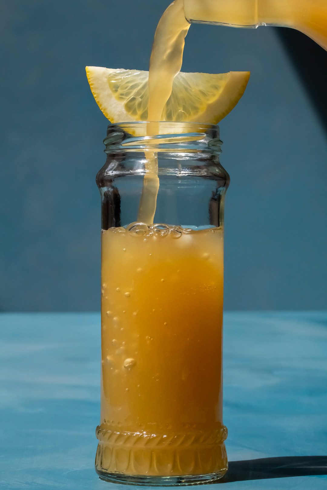pouring ginger beer for a Pickle Gin Buck Cocktail
