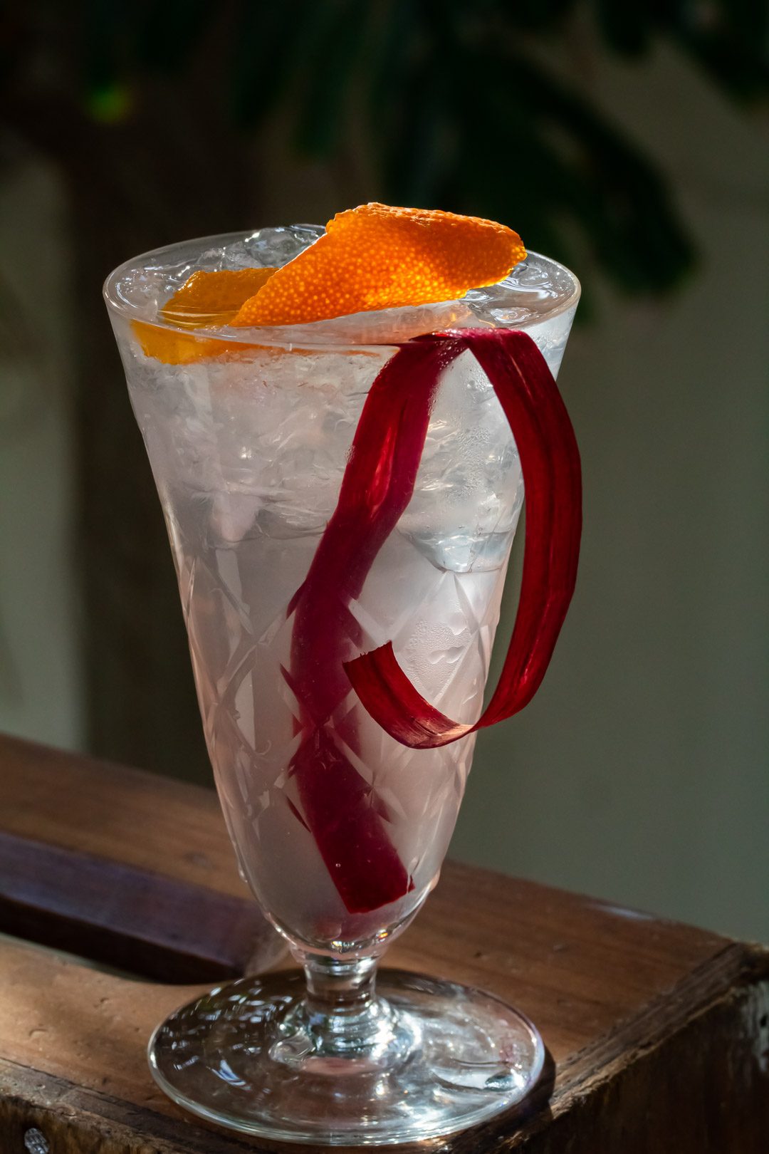 rhubarb shrub gin fix cocktail on wooden box from close up