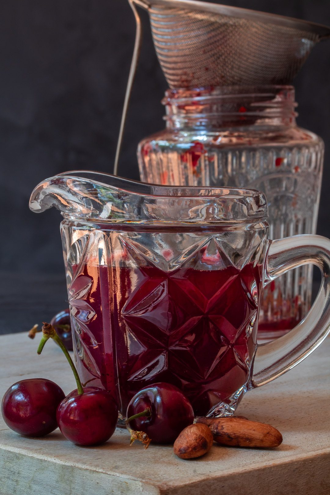 cherry shrub syrup in vintage cut glass jug for cherry shrub brandy daisy