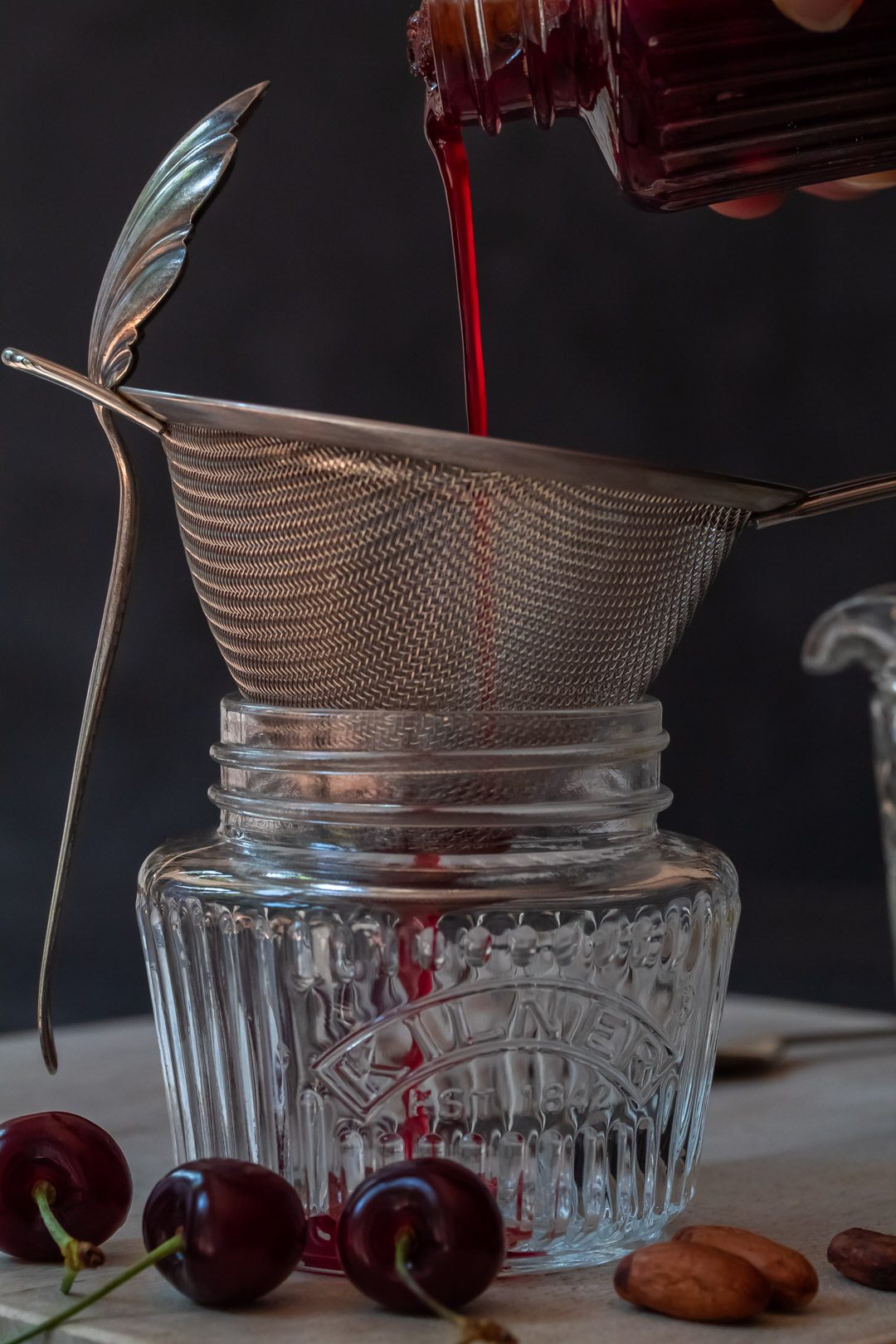 pouring cherry shrub syrup for cherry shrub brandy daisy