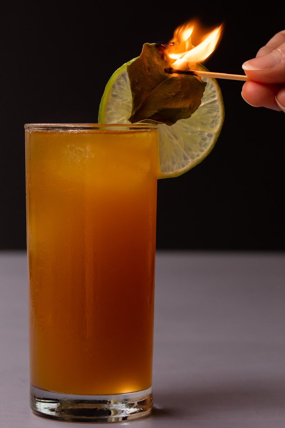 lime lightening dark 'n stormy with flamed kaffir lime leaf garnish