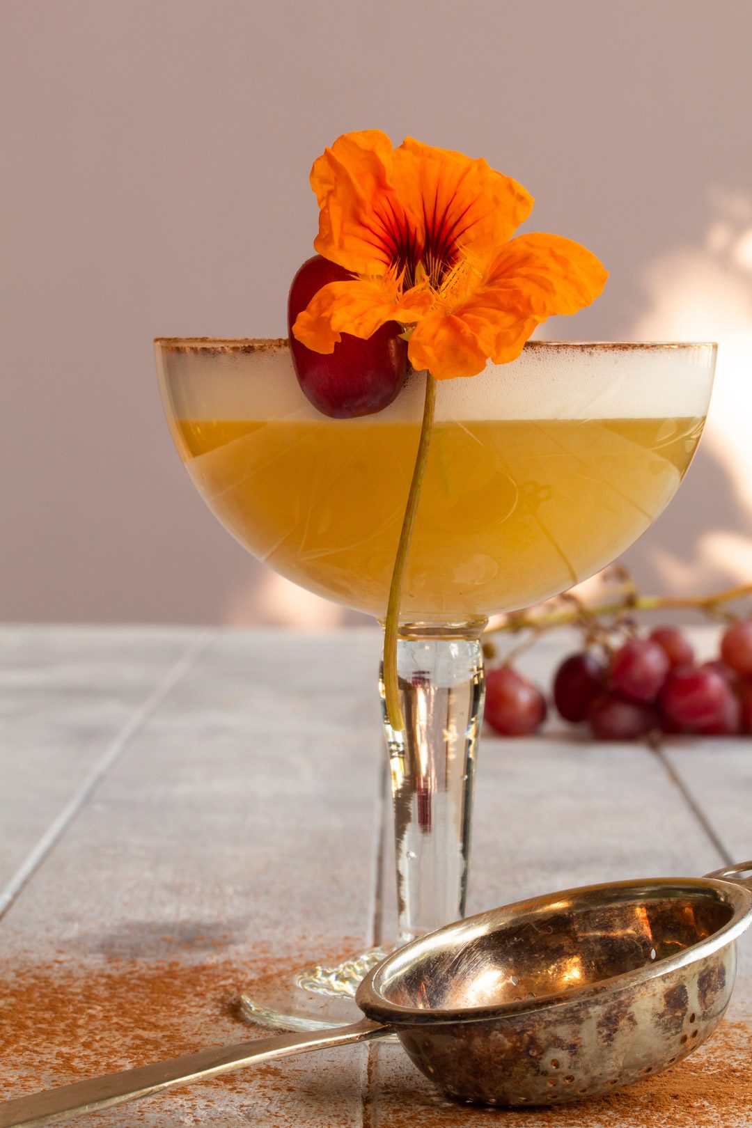 Autumn grape silver sour: with tea strainer and grapes in background