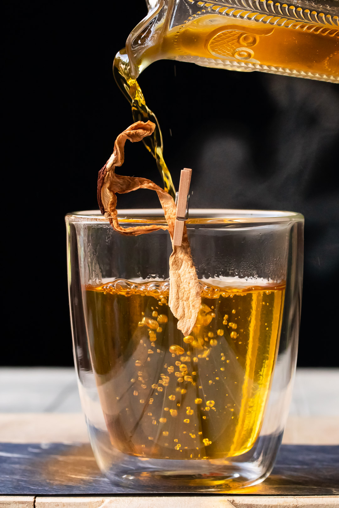 end pouring shiitake saffron infusion for umami hot whiskey toddy