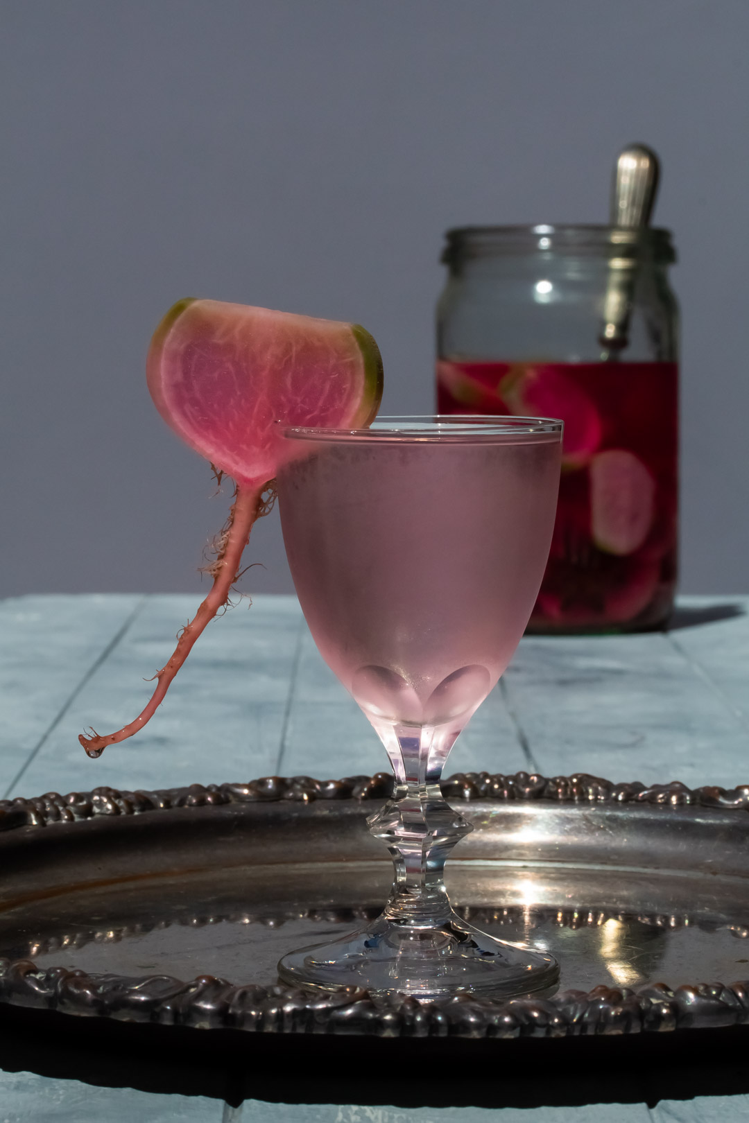 fermented watermelon radish martini with drip and pickles in far background