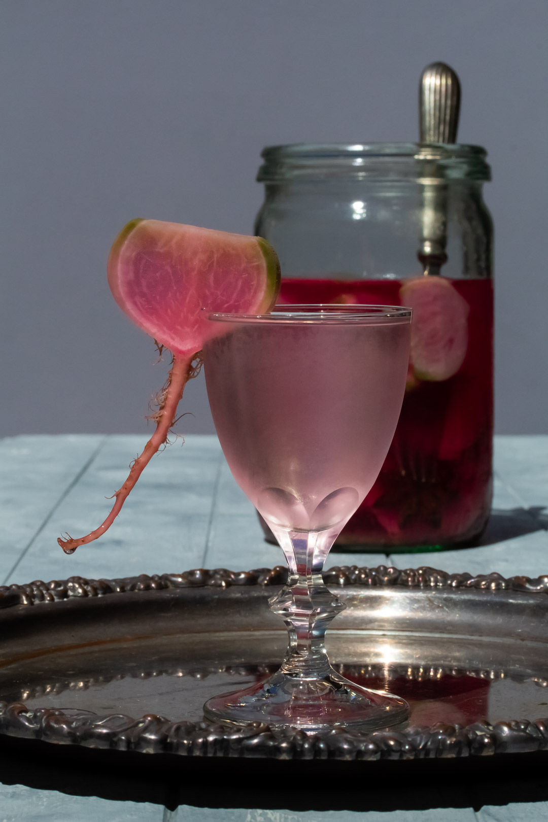 fermented watermelon radish martini with drip and pickles in background