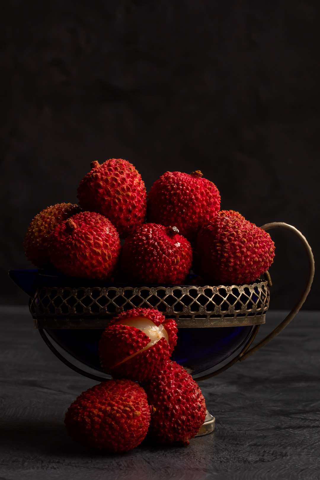 fresh lychees in vintage cream jug for lychee reviver cocktail with lychees in foreground