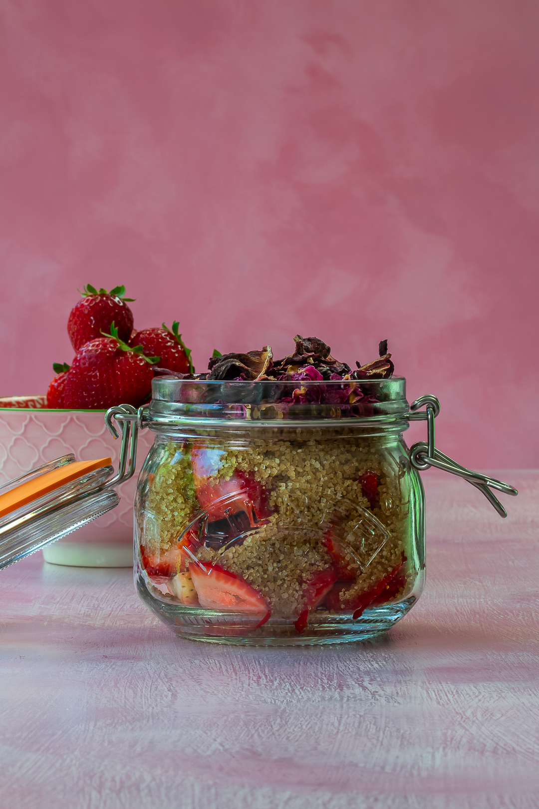 strawberries, demerara sugar, rose petals and hibiscus for making strawberry syrup for use in strawberry tequila collins