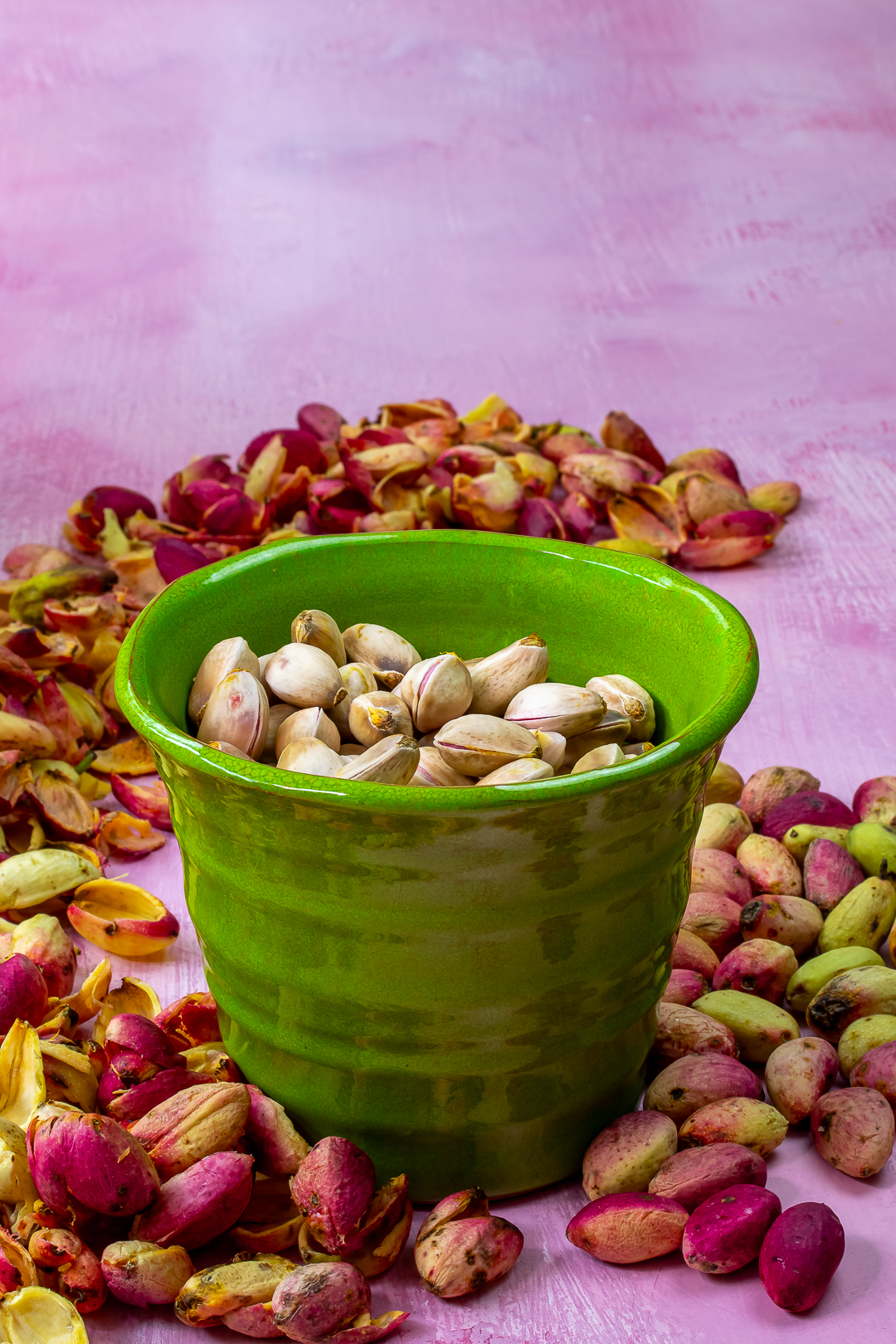 shelled pistachios in green pot with shells and fresh pistachios for making fresh pistachio syrup for pistachio limeade