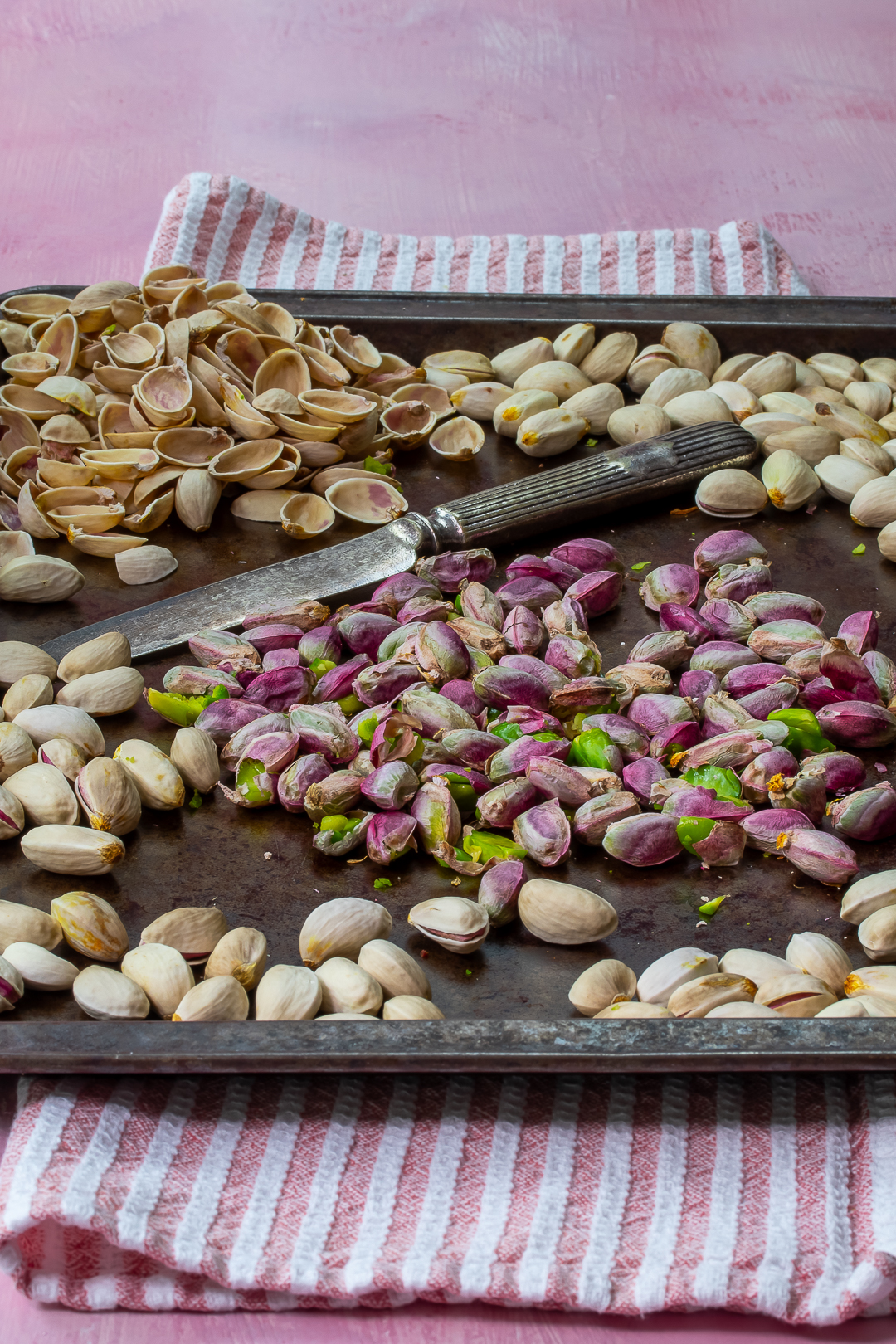 shelled pistachios with knife, shells and roasted pistachios for making pistachio syrup for pistachio limeade